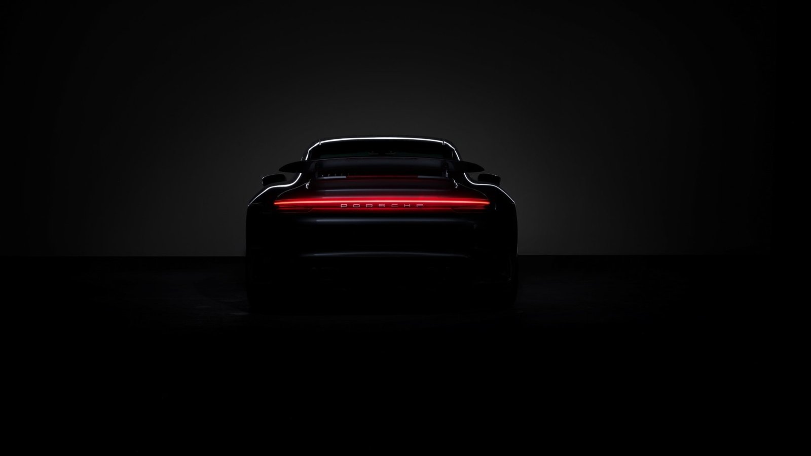 Farol traseiro de um Porsche às escuras, com a luz vermelha acesa