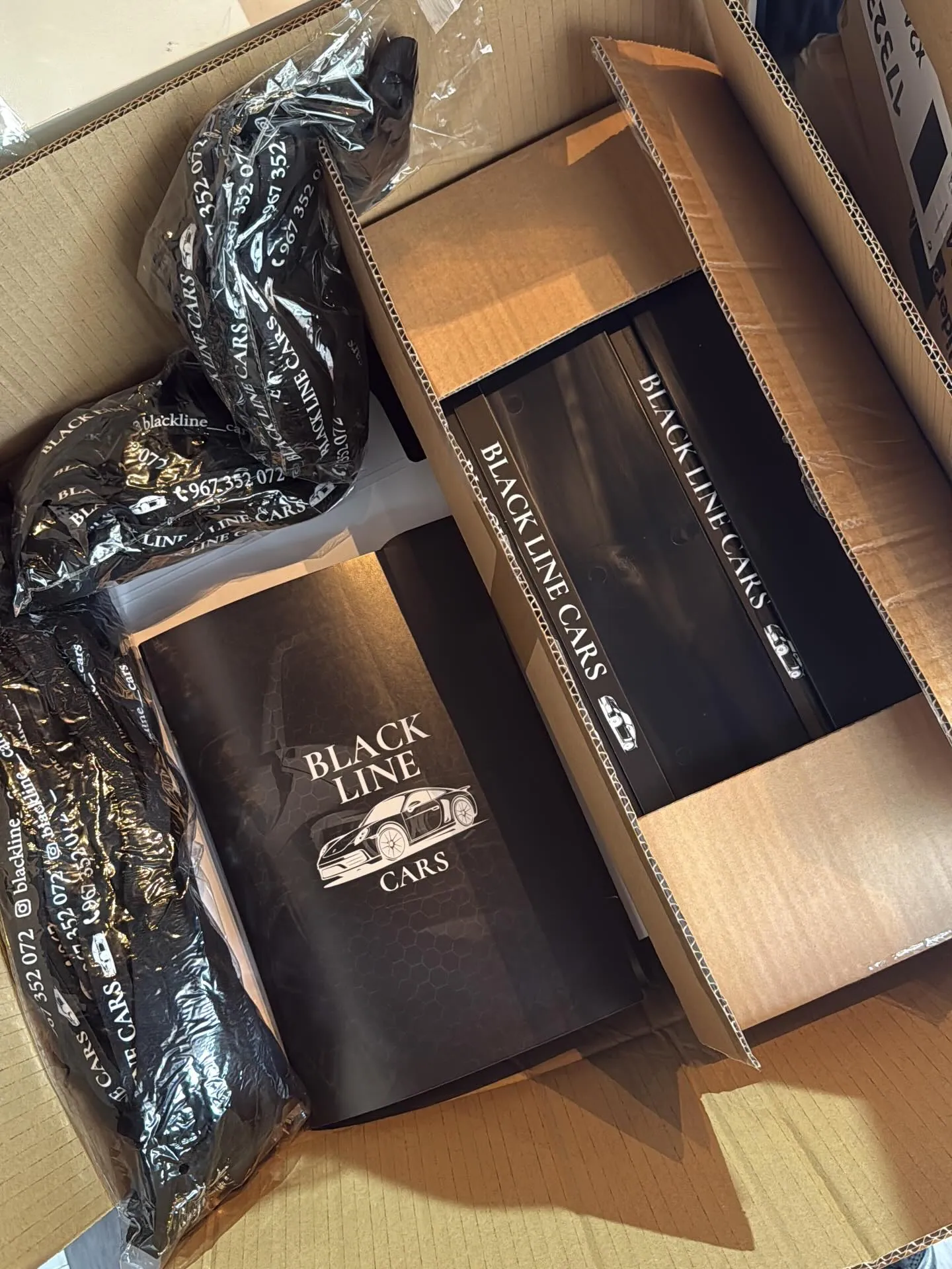 Pastas pretas da Black Line Cars numa caixa de entrega